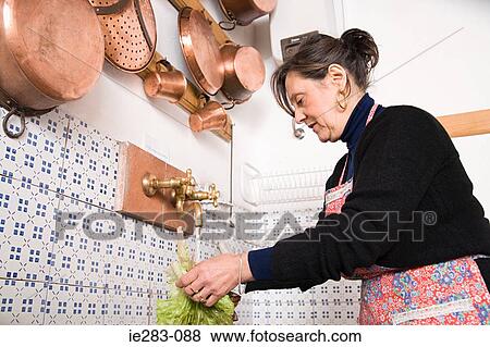 Stock Photo - Woman washing lettuce. Fotosearch
