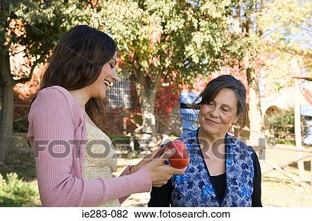 Stock Image - Women holding a tomato. Fotosearch