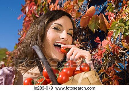 Young woman eating tomatoes View Large Photo Image Stock Photo - Young woman eating tomatoes. Fotosearch