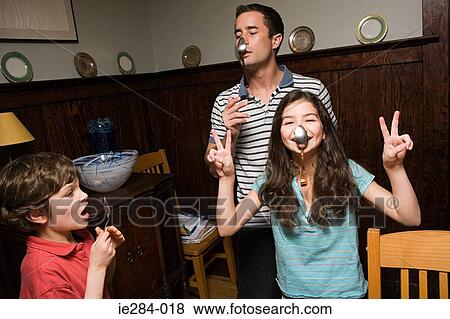 A father and his children hanging spoons on their noses View Large Photo Image Stock Photo - A father and his children hanging spoons on their noses. Fotosearch
