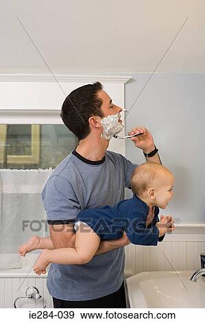 A father shaving and holding a baby View Large Photo Image Stock Photo - A father shaving and holding a baby. Fotosearch