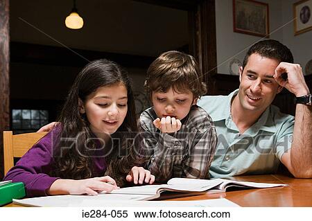 A father supervising his children with their homework View Large Photo Image Stock Photography - A father supervising his children with their homework. Fotosearch