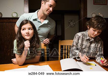 A father supervising his childrens homework View Large Photo Image Stock Photo - A father supervising his childrens homework. Fotosearch