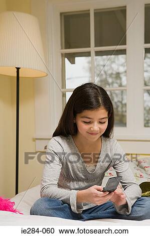 A girl texting on her cell phone View Large Photo Image Stock Image - A girl texting on her cell phone. Fotosearch