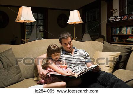Stock Photography - Father and daughter reading a book. Fotosearch