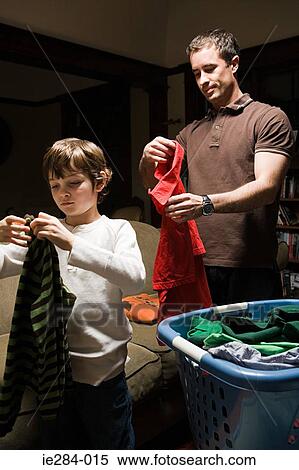 Stock Photography - Father and son folding laundry. Fotosearch