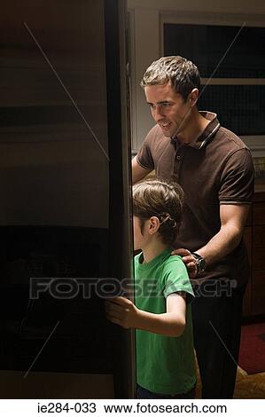 Father and son looking in a fridge View Large Photo Image Stock Image - Father and son looking in a fridge. Fotosearch