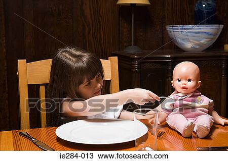 Girl feeding a doll View Large Photo Image Stock Image - Girl feeding a doll. Fotosearch