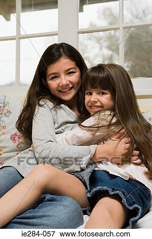 Stock Photo - Sisters hugging. Fotosearch