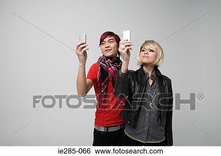 Stock Photograph - Couple using camera telephones. Fotosearch