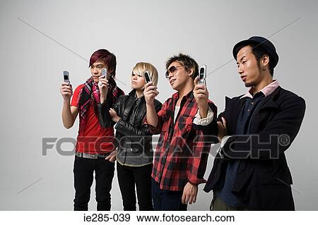 Stock Photo - Four people using camera telephones. Fotosearch