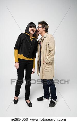 Stock Image - Japanese couple whispering. Fotosearch