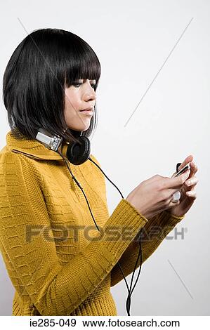 Woman listening to an mp3 player View Large Photo Image Stock Photo - Woman listening to an mp3 player. Fotosearch