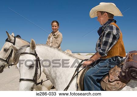 A boy and girl riding horses View Large Photo Image Stock Image - A boy and girl riding horses. Fotosearch