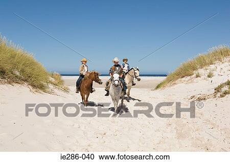 Stock Image - A boy and girls riding horses. Fotosearch