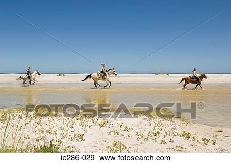 Stock Photo - A boy and girls riding horses. Fotosearch