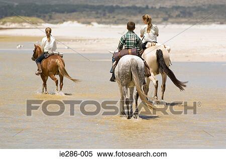 Stock Photography - A boy and girls riding horses. Fotosearch