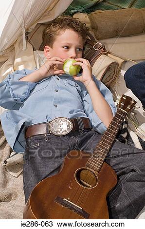 A boy eating an apple View Large Photo Image Stock Image - A boy eating an apple. Fotosearch