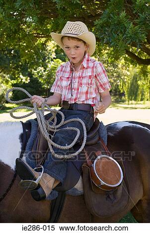 A boy riding a horse and holding a lasso View Large Photo Image Stock Photography - A boy riding a horse and holding a lasso. Fotosearch