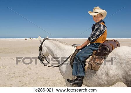 Stock Image - A boy riding a horse. Fotosearch
