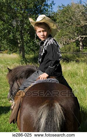 A boy riding a horse View Large Photo Image Stock Photography - A boy riding a horse. Fotosearch