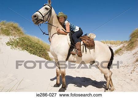 A girl riding a horse View Large Photo Image Stock Photo - A girl riding a horse. Fotosearch