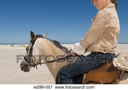 Stock Photo - A girl riding a horse. Fotosearch