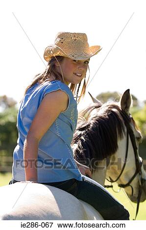 Stock Photo - A girl riding a horse. Fotosearch