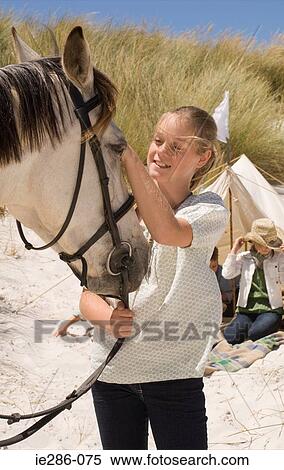 A girl stroking a horse View Large Photo Image Stock Photography - A girl stroking a horse. Fotosearch