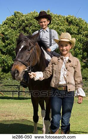 A girl walking a boy on a horse View Large Photo Image Stock Image - A girl walking a boy on a horse. Fotosearch