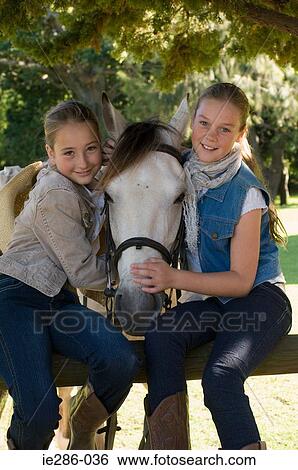Portrait of two girls and a horse View Large Photo Image Stock Photograph - Portrait of two girls and a horse. Fotosearch