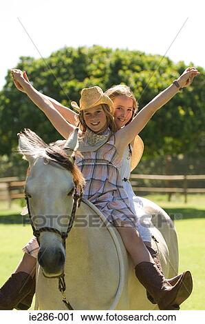 Two girls riding a horse View Large Photo Image Stock Image - Two girls riding a horse. Fotosearch