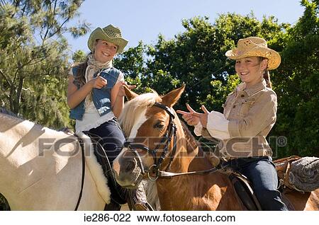 Two girls riding horses View Large Photo Image Stock Image - Two girls riding horses. Fotosearch