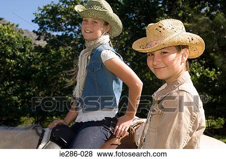 Stock Photo - Two girls riding horses. Fotosearch