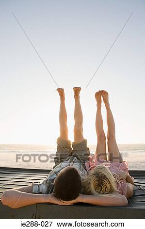 A couple lying down with their feet in the air View Large Photo Image Stock Photo - A couple lying down with their feet in the air. Fotosearch