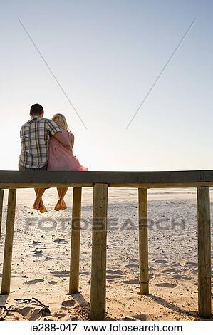 A couple sat on a pier View Large Photo Image Stock Photo - A couple sat on a pier. Fotosearch