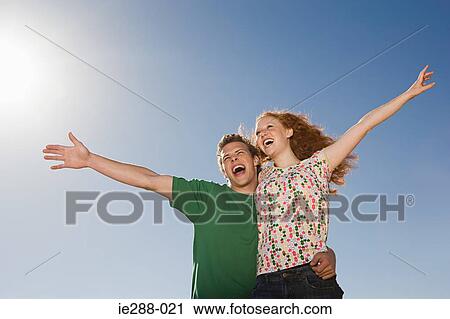 A couple with their arms raised View Large Photo Image Stock Image - A couple with their arms raised. Fotosearch