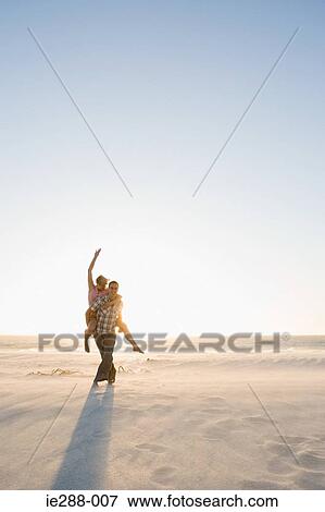 A man giving a woman a piggy back View Large Photo Image Stock Photo - A man giving a woman a piggy back. Fotosearch