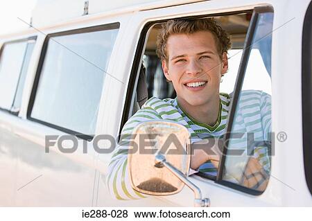 Stock Photo - A young man in a camper van. Fotosearch