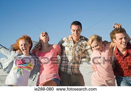Friends arm in arm on a beach View Large Photo Image Stock Image - Friends arm in arm on a beach. Fotosearch