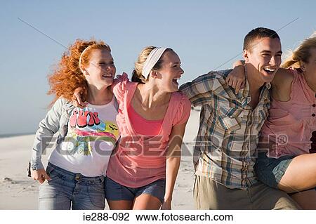Friends arm in arm on a beach View Large Photo Image Stock Image - Friends arm in arm on a beach. Fotosearch