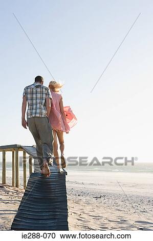 Stock Image - Rear view of a couple on a pier. Fotosearch