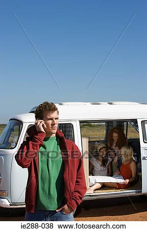Young man using a cell phone View Large Photo Image Stock Photo - Young man using a cell phone. Fotosearch