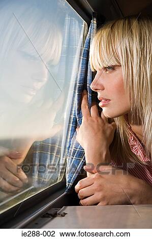 Young woman looking out of window View Large Photo Image Stock Image - Young woman looking out of window. Fotosearch