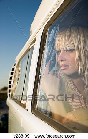 Young woman looking out of window View Large Photo Image Stock Image - Young woman looking out of window. Fotosearch