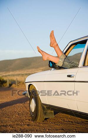 Young womans feet sticking out of a car window View Large Photo Image Stock Image - Young womans feet sticking out of a car window. Fotosearch