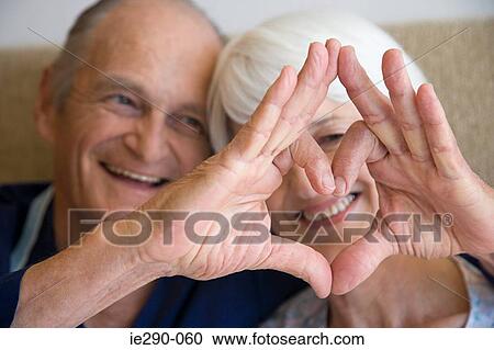 A couple making a heart shape with their hands View Large Photo Image Stock Image - A couple making a heart shape with their hands. Fotosearch
