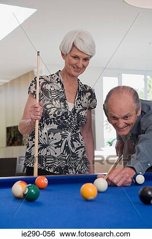 Stock Photograph - A senior couple playing pool. Fotosearch