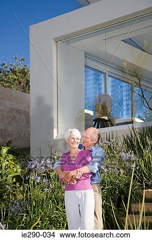 A senior couple stood in their garden View Large Photo Image Picture - A senior couple stood in their garden. Fotosearch