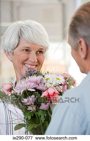 A senior man giving a senior woman flowers View Large Photo Image Stock Photo - A senior man giving a senior woman flowers. Fotosearch